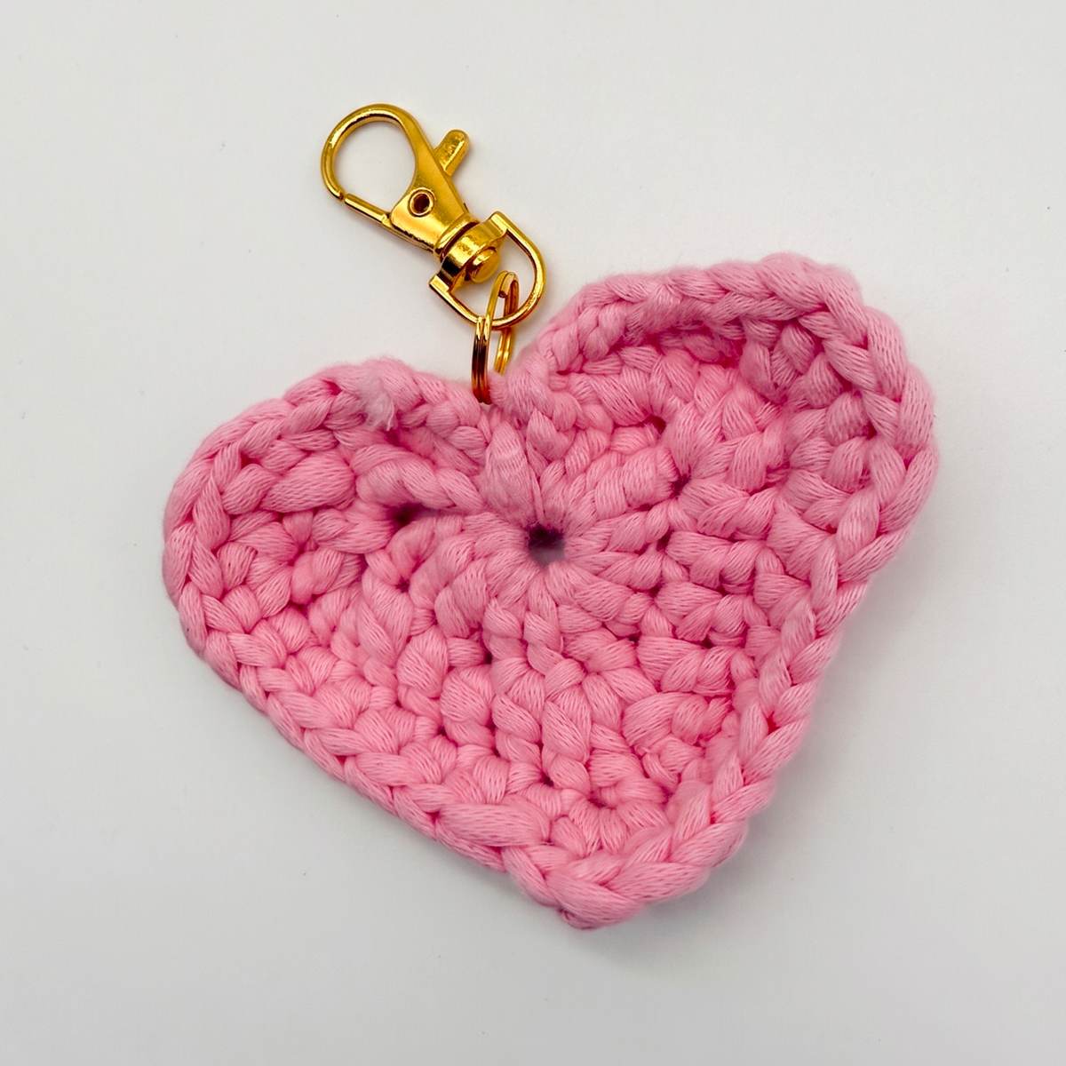 Crocheted heart bag charm with a gold clasp